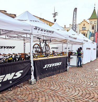 The Stevens Bikes promotion tent is a 4x2 m folding gazebo in white. The side walls are black and white. The bikes are located under the folding gazebo.