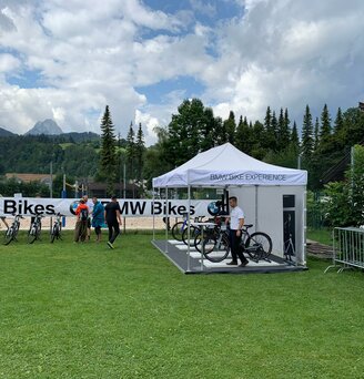 White 6x3 gazebo customised with BMW Bike experience lettering with side wall in a meadow with tree and mountain backdrop 